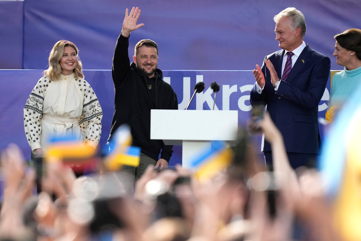 Na snímke druhý zľava ukrajinský prezident Volodymyr Zelenskyj pozdravuje publikum, druhý sprava litovský prezident Gitanas Nauseda na pódiu počas samitu NATO v litovskom Vilniuse 11. júla 2023.