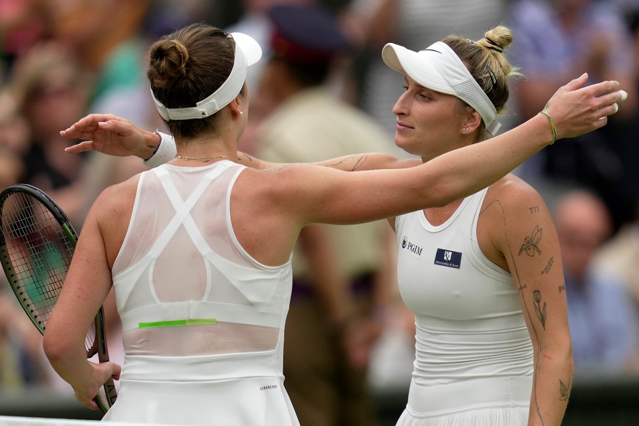 Česká tenistka Markéta Vondroušová (vpravo) a Jelina Svitolinová z Ukrajiny sa objímajú po semifinále ženskej dvojhry na grandslamovom turnaji vo Wimbledone vo štvrtok 13. júla 2023.