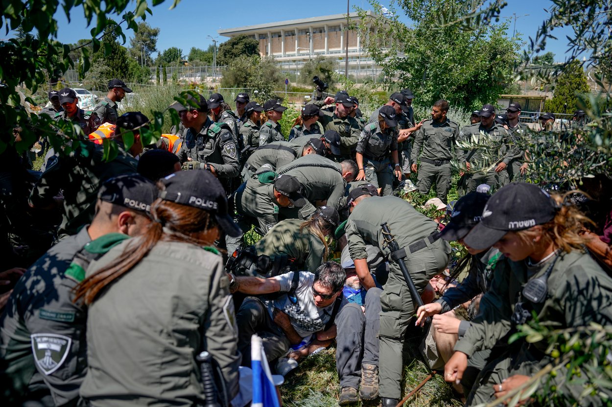 Príslušníci izraelskej pohraničnej polície sa potýkajú s demonštrantmi počas protestu proti  zákone o reforme súdnictva pred Knesetom v Jeruzaleme 24. júla 2023 v Jeruzaleme.