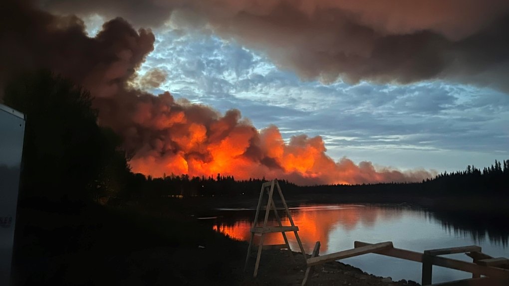 Valiaci sa dym z lesných požiarov pri kanadskej rieke Hay River.