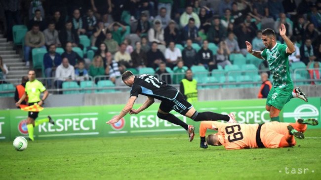 Na snímke uprostred padá futbalista Aleksandar Čavrič (Slovan), dole brankár Matevž Vidovšek (Ľubľana) a vpravo Marko Mijailovič (Ľubľana) počas zápasu 2. kola A-skupiny Európskej konferenčnej ligy Olimpija Ľubľana - ŠK Slovan Bratislava 5. októbra 2023 v Ľubľane.