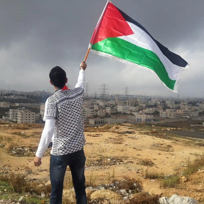 ilustračná foto - muž mávajúci vlajkou Palestíny