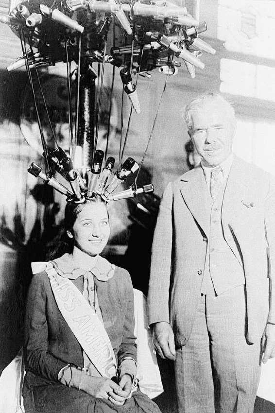 Nemecký kaderník Karl Nessler sa spokojne pozerá na Miss Amerika 1926, ktorá tiež vyskúšala jeho trvalú.