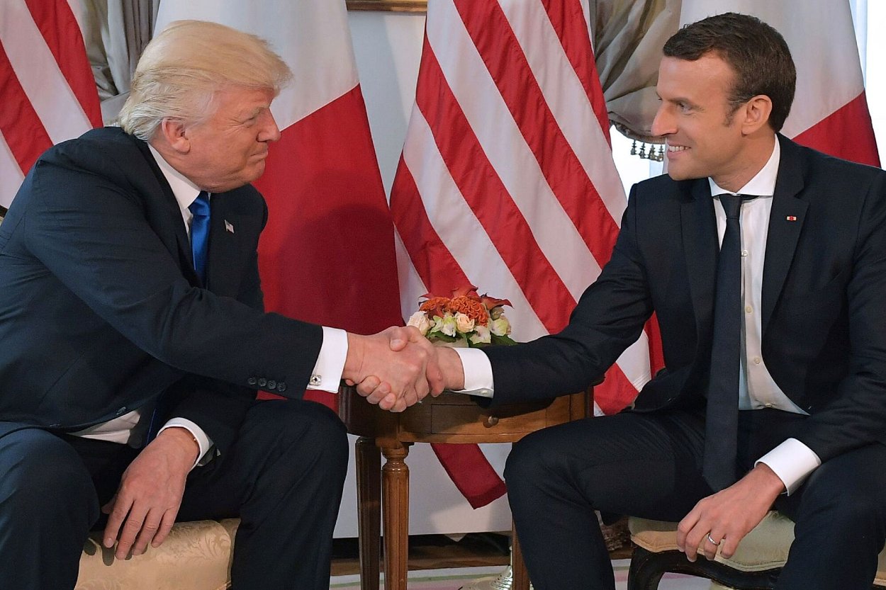 Donald Trump a Emmanuel Macron si podávajú ruky pred pracovným obedom v rámci summitu NATO v máji 2017.