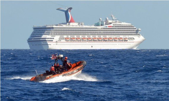 Snímka, ktorú zverejnila americká pobrežná stráž 11. februára 2013, ukazuje malú loď patriacu hliadkam Coast Guard Cutter Vigorous v blízkosti výletnej lode „Triumph“ v Mexickom zálive.