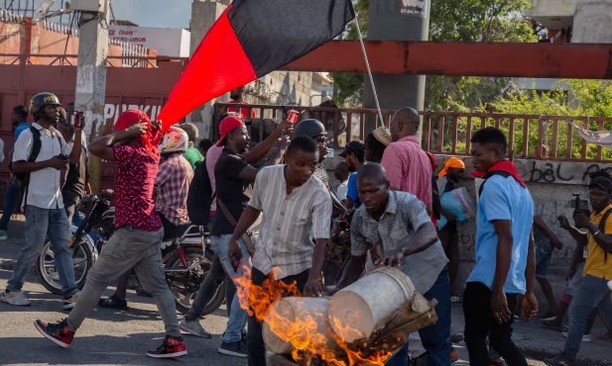 Ľudia podpaľovali pneumatiky počas demonštrácie požadujúcej odstúpenie haitského premiéra Ariela Henryho v Port-au-Prince na Haiti 7. marca 2024.