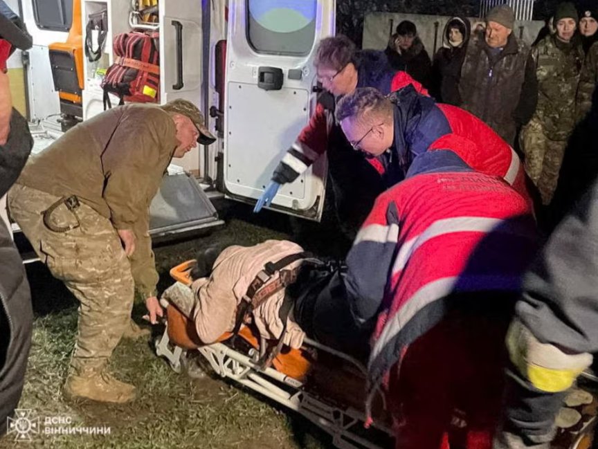 Záchranári prevážajú zranenú osobu do sanitného vozidla na mieste obytnej budovy poškodenej počas útoku ruského bezpilotného lietadla uprostred ruského útoku na Ukrajinu v regióne Vinnytsia na Ukrajine, na tejto fotke zverejnenej 15. marca 2024.