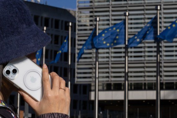 Ilustračná foto - žena hovorí cez iPhone v budove Berlaymont, centrále Európskej komisie, v Bruseli, Belgicko, 4. marca 2024.
