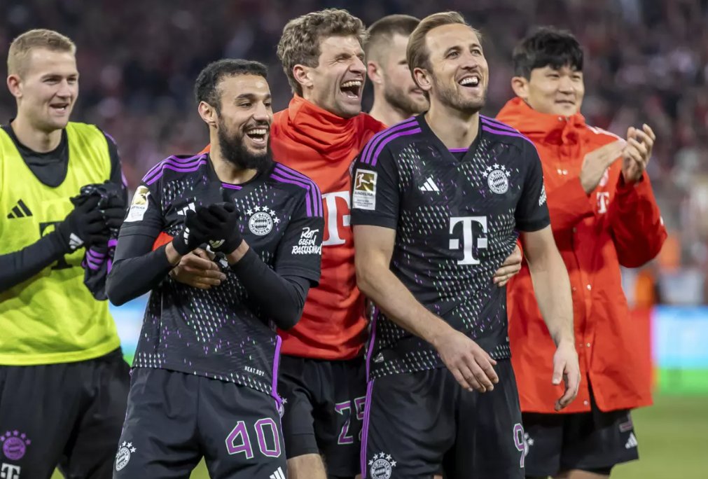 Noussair Mazraoui, zľava Thomas Müller a Harry Kane z Bayernu Mníchov oslavujú pred publikom po zápase nemeckej futbalovej Bundesligy medzi FC Union Berlín a Bayernom Mníchov na štadióne An der Alten Forsterei v Berlíne v sobotu 20. apríla 2024.