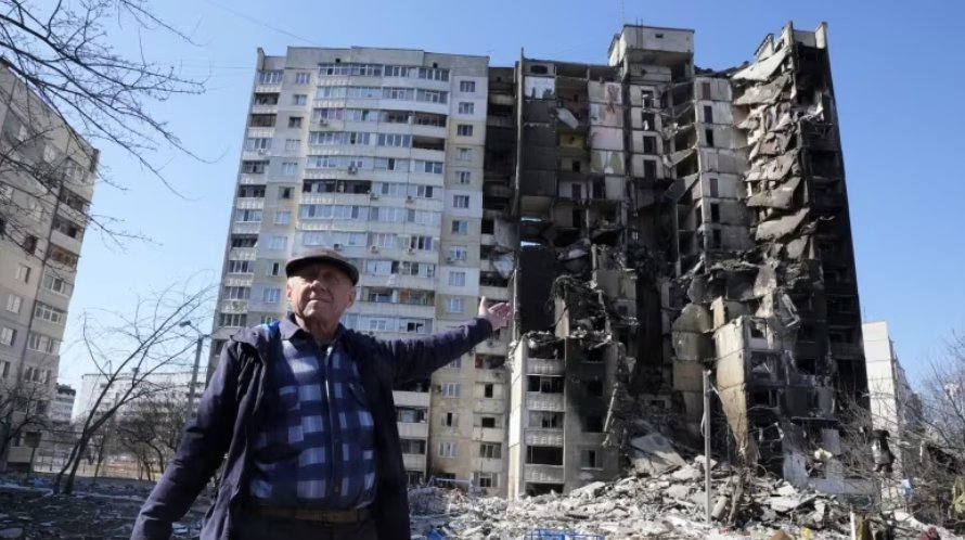 Muž ukazuje na svoj zničený dom po ruskom bombardovaní v Charkove na Ukrajine 24. marca.