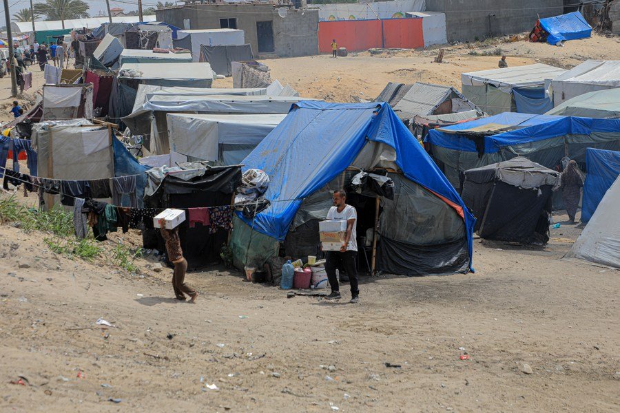 Ľudia sú videní v dočasnom tábore v meste Rafah na juhu Pásma Gazy 27. apríla 2024.