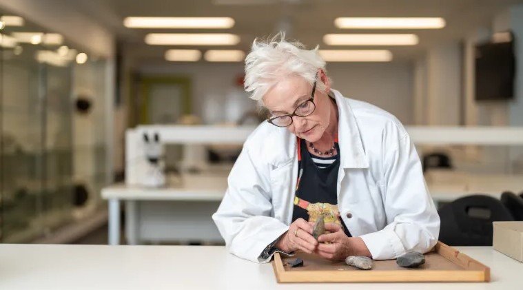 Sue O’Connor, profesorka na Škole kultúry, histórie a jazyka na Austrálskej národnej univerzite, skúma leštenú kamennú hlavu sekery nájdenú na ostrove Timo.