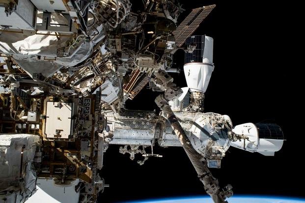 Na tejto fotografii z fotoaparátu astronauta NASA Woodyho Hoburga počas šesťhodinovej a trojminútovej vychádzky do vesmíru sú zobrazené dve vozidlá SpaceX Dragon priložené k modulu Harmony Medzinárodnej vesmírnej stanice.