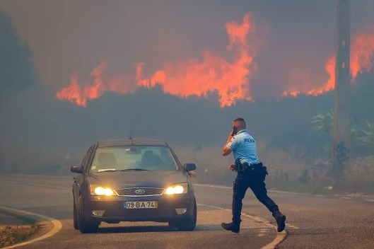 Policajt riadi dopravu počas lesného požiaru v Alcabideche, Cascais, Portugalsko