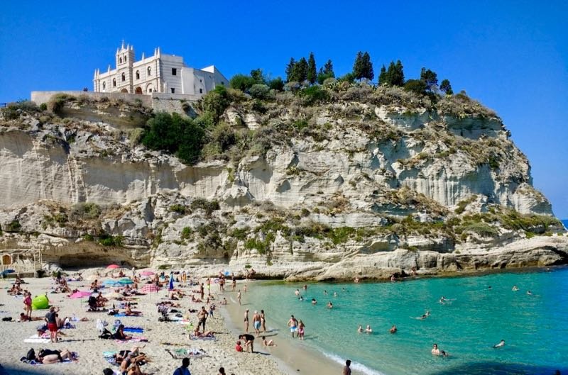 Tropea je impozantné prímorské mesto na západnom pobreží Kalábrie s ikonickými domami zabudovanými na vrchole útesu a širokými výhľadmi na tyrkysový oceán.