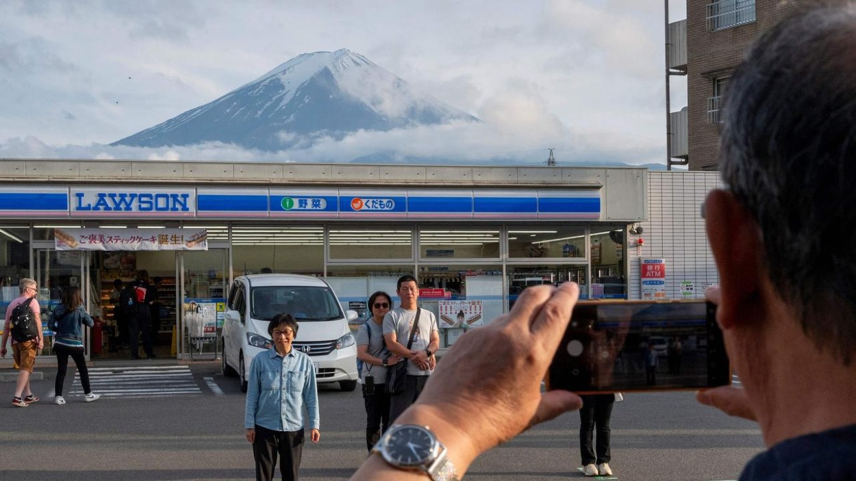 Turisti sa fotia pred horou Fudži na obľúbenom mieste oproti obchodu so zmiešaným tovarom v meste Fujikawaguchiko v prefektúre Yamanashi.