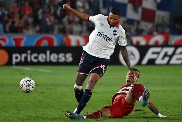 Obranca Nacional Juan Manuel Izquierdo (vľavo) bojuje o loptu počas tretieho kola Copa Libertadores