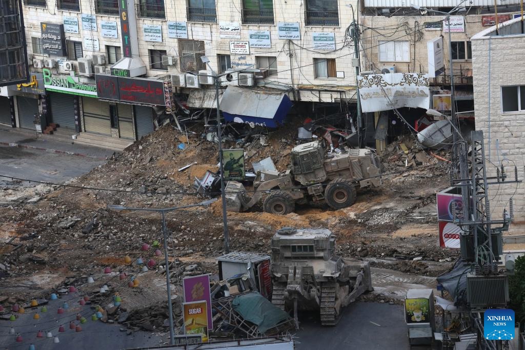 Izraelský buldozér a nakladač ničia cestu v meste Jenin na severe Západného brehu Jordánu 2. septembra 2024.