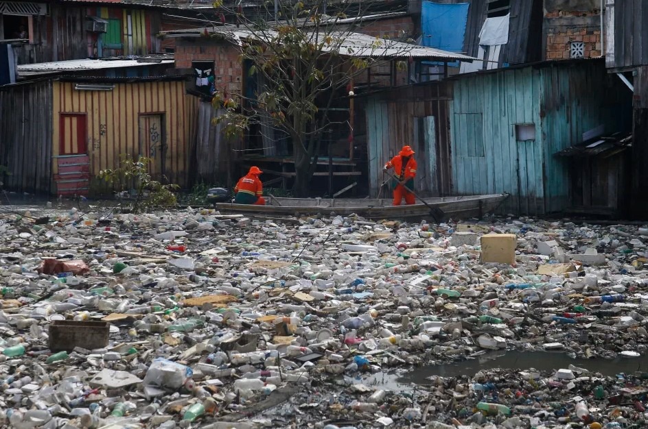 Mestskí pracovníci odstraňujú odpadky plávajúce na rieke Negro, ktorej hladina stúpla v dôsledku dažďa, v Manause, štát Amazonas, Brazília, 6. júna 2022.