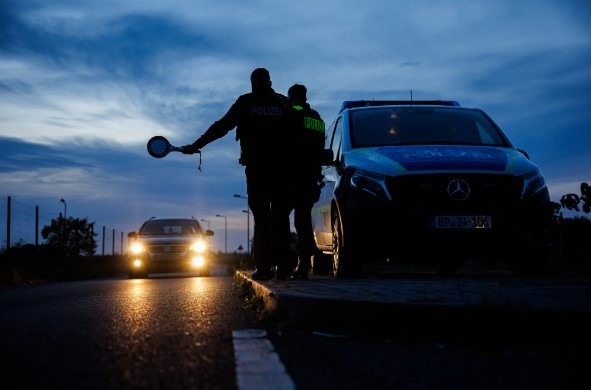 Nemeckí spolkoví policajti zastavujú auto pri Forste vo východnom Nemecku počas minuloročnej hliadky pri hraniciach s Poľskom.