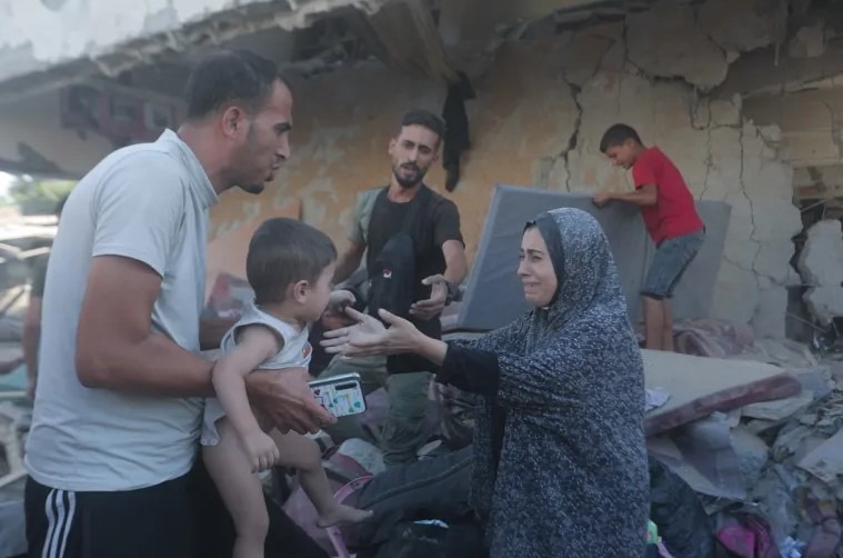 Palestínska žena sa naťahuje za svojím synom po tom, čo izraelská armáda zaútočila na školu al-Jaouni, kam sa uchýlili tisíce vysídlencov v utečeneckom tábore Nuseirat v Deir el-Balah v Gaze 11. septembra 2024.