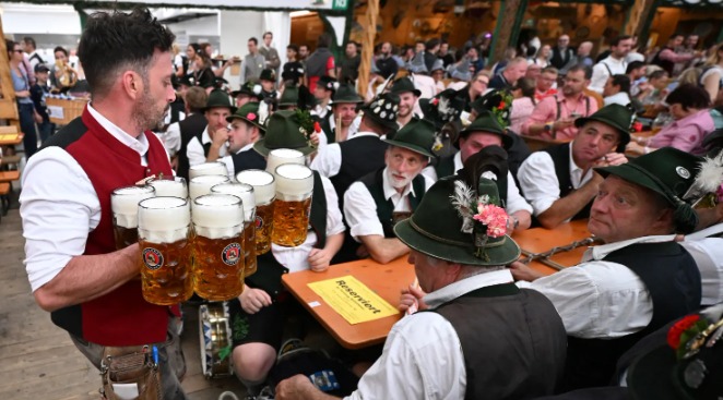 Čašník prináša pivo na stôl počas Oktoberfestu v Mníchove, Nemecko 22. septembra 2024. Najväčší pivný festival na svete sa končí 6. októbra 2024.