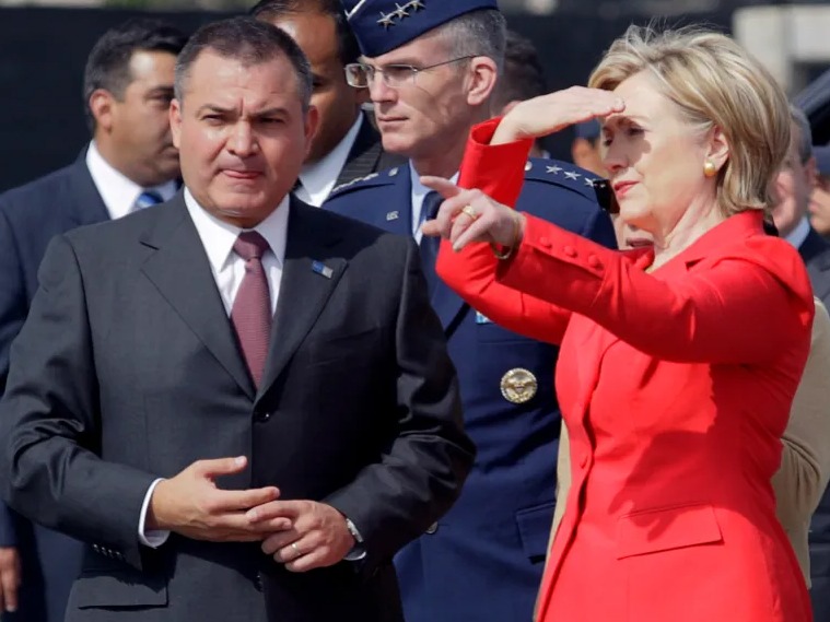 Mexický minister verejnej bezpečnosti Genaro Garcia Luna stojí vedľa americkej ministerky zahraničných vecí Hillary Clintonovej počas návštevy federálneho policajného centra v Mexico City 26. marca 2009.