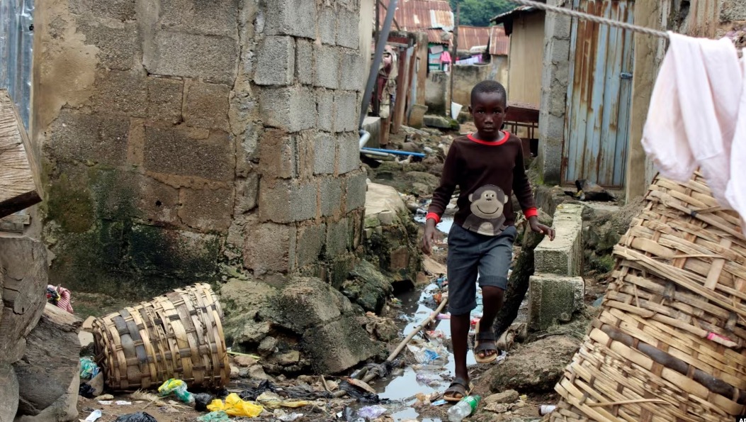 Ilustračné foto - chlapec prechádza okolo kanalizácie okolo domov v Abuji, Nigéria, 3. septembra 2021. 