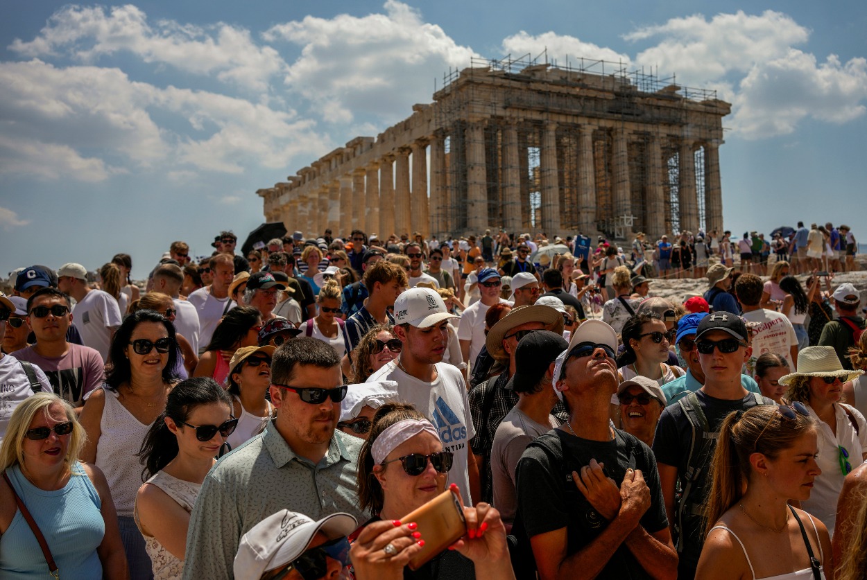 Turisti navštevujú chrám Parthenón na vrchole starovekého kopca Akropolis v Aténach, Grécko, utorok 4. júla 2023.