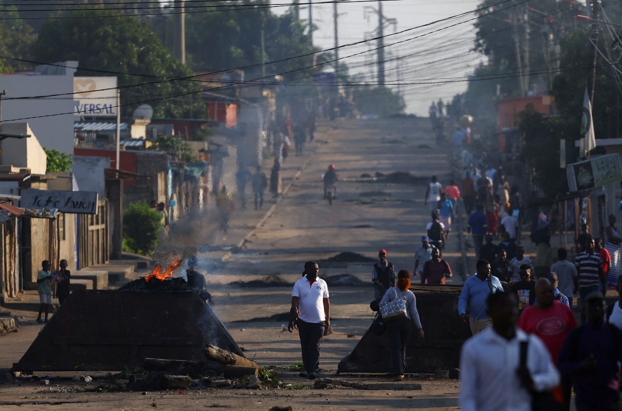 Miestni obyvatelia prechádzajú okolo barikád, ktoré použili demonštranti po tom, ako bola vládnuca strana Frelimo vyhlásená za víťaza sporných volieb tento mesiac, v Mapute, Mozambik, 25. októbra 2024.