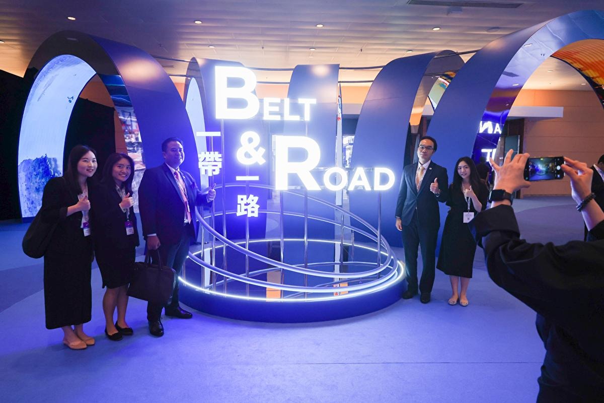 Na tejto súbornej fotke z 13. septembra 2023 ľudia pózujú s inštaláciou s nápisom „Belt and Road“ počas samitu Belt and Road v roku 2023 v Hongkongskom kongresovom a výstavnom centre vo Wan Chai.