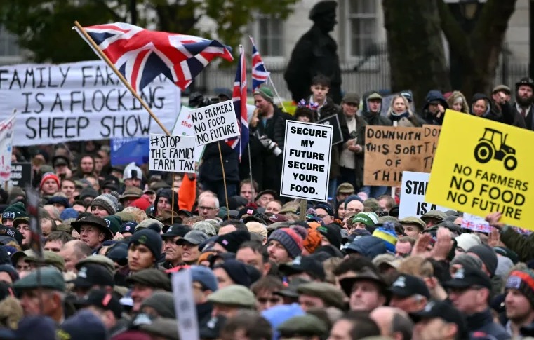 Demonštranti počúvajú rečníkov počas protestu farmárov proti zmenám pravidiel dedičskej dane pre vlastníctvo pôdy pred Downing Street na Whitehall v centre Londýna.