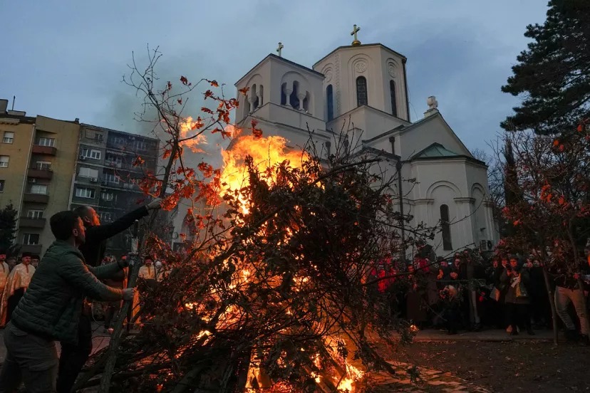 Ľudia pália sušené dubové vetvičky, symbol julského polena na pravoslávny Štedrý deň, pred kostolom svätého Sávu v Belehrade v Srbsku.