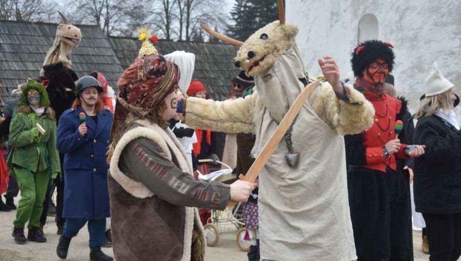 Maska turoňa v popredí záberu z fašiangových osláv v Múzeu slovenskej dediny.