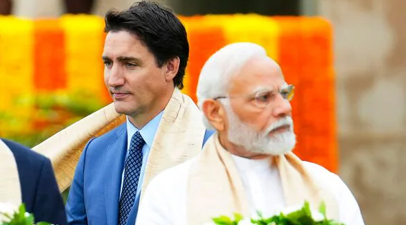 Kanadský premiér Justin Trudeau (vľavo) prechádza okolo indického premiéra Naréndru Módího počas ceremoniálu kladenia vencov v Rádž Gháte počas summitu G20 v Naí Dillí.