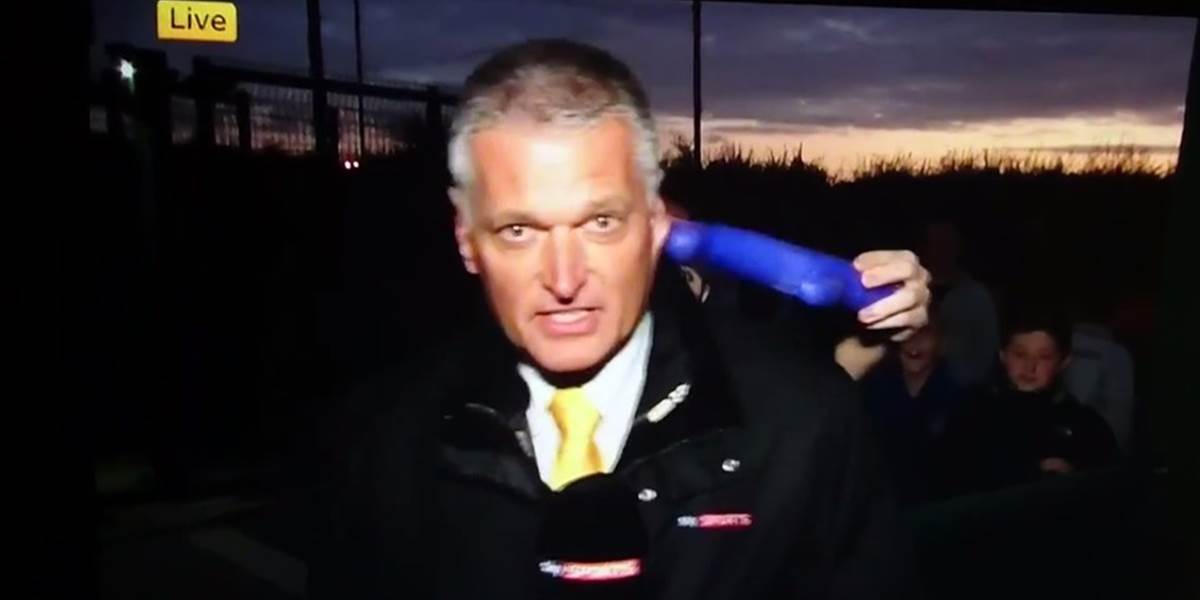 VIDEO Fanúšik strkal reportérovi do ucha umelý penis