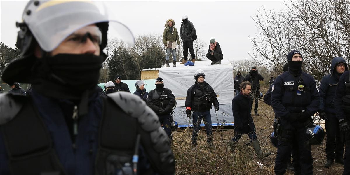 FOTO Demolácia táboru Džungľa pri Calais pokračuje, migranti protestujú na strechách búd